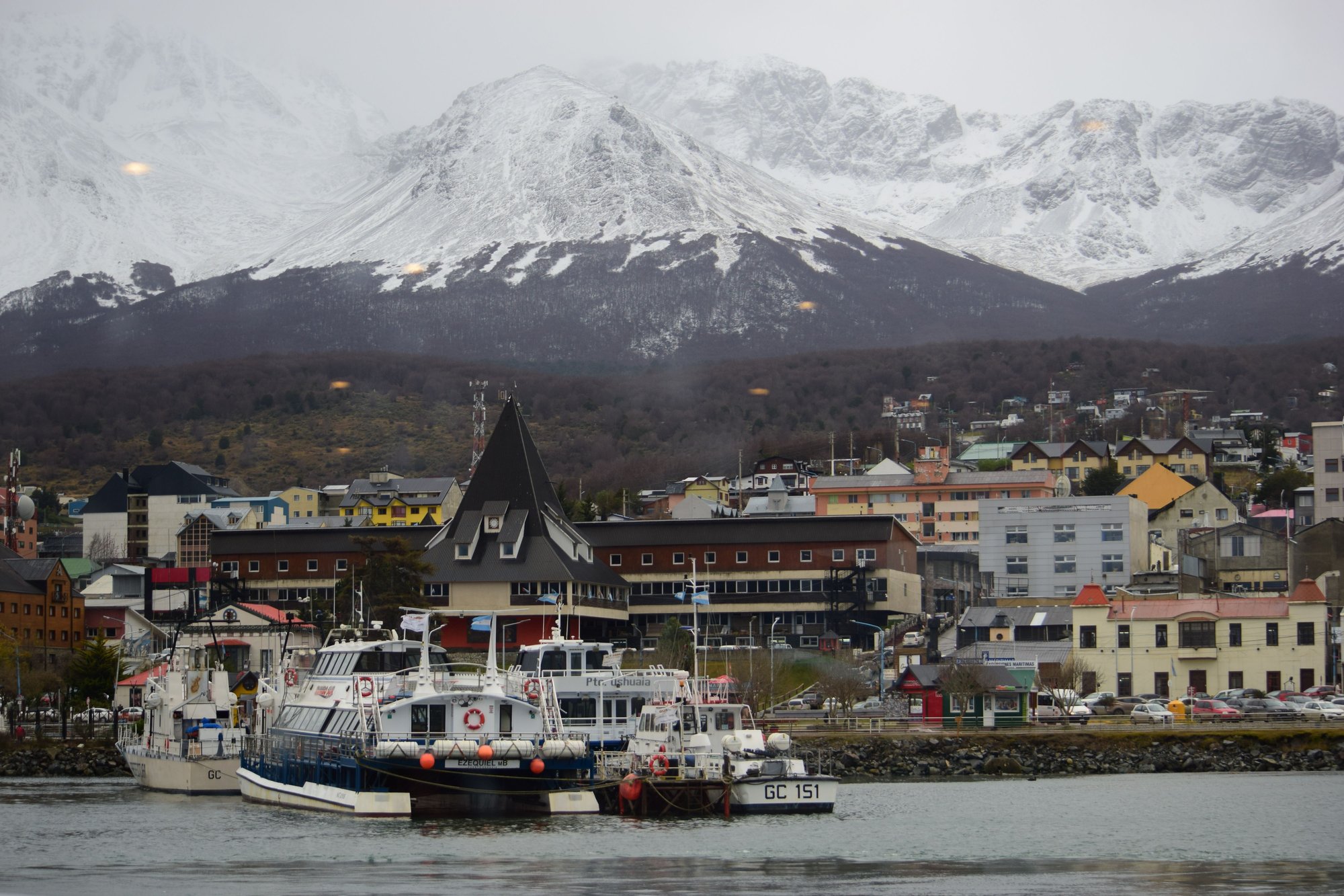 Ushuaia harbor with expedition boats and snow-capped mountains